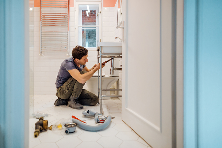 man with home repair expense fixing sink